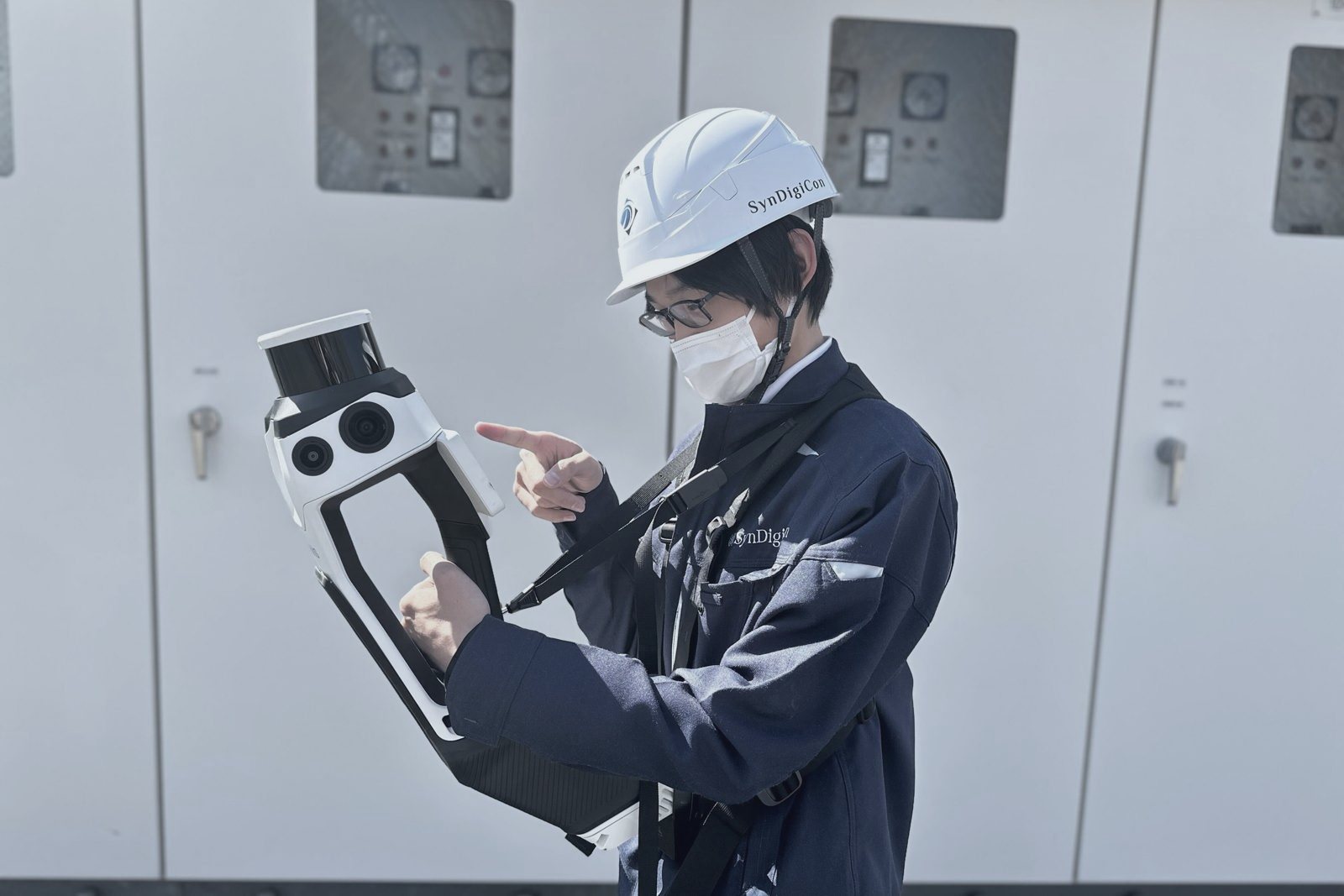 3Dスキャナを構えて現場を計測する社員