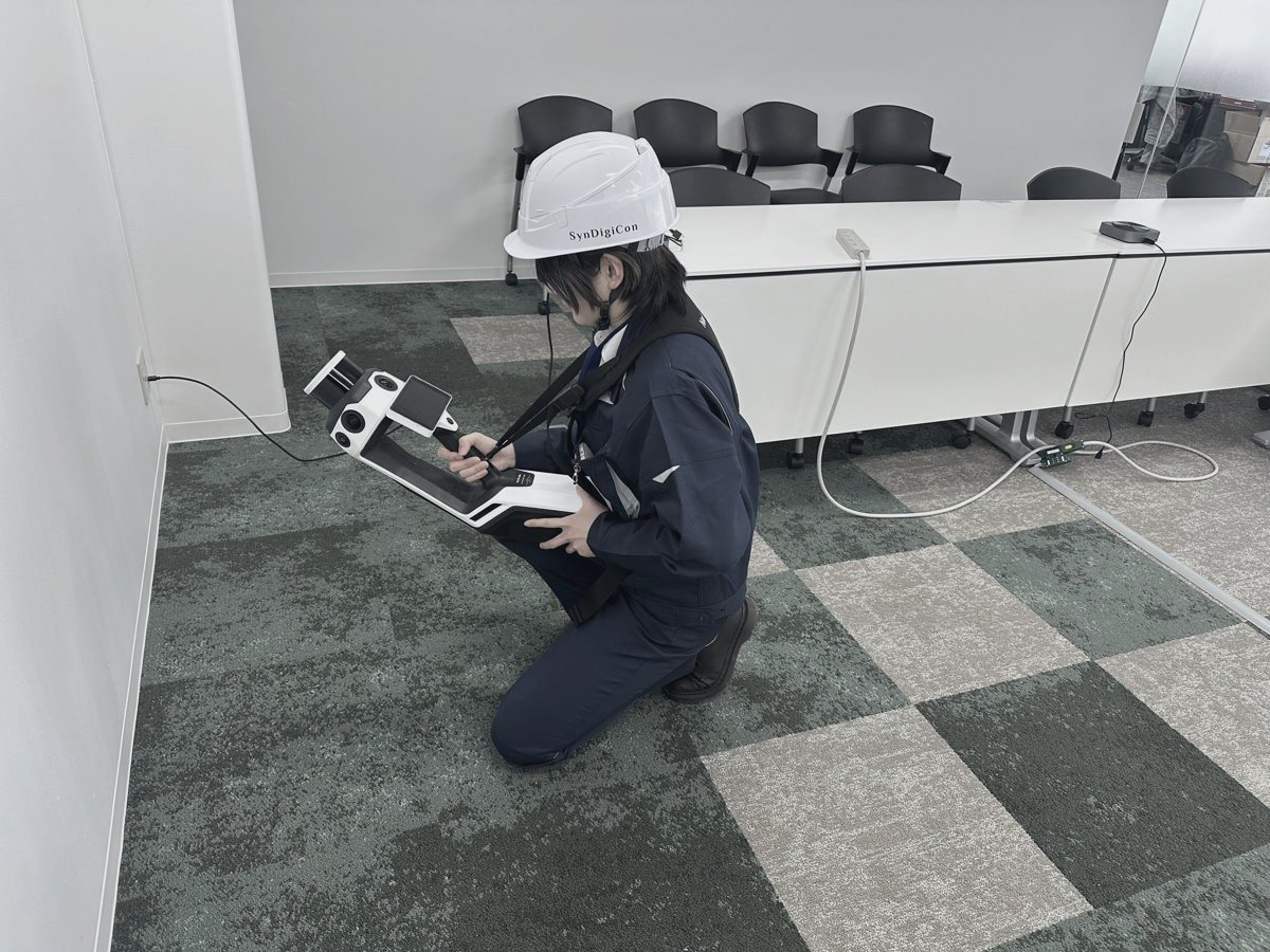 しゃがんで機材を操作する社員